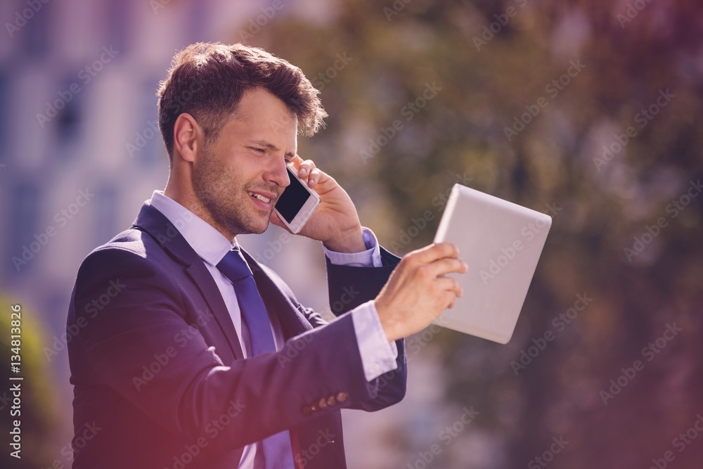 Businessman using mobile phone and digital tablet 