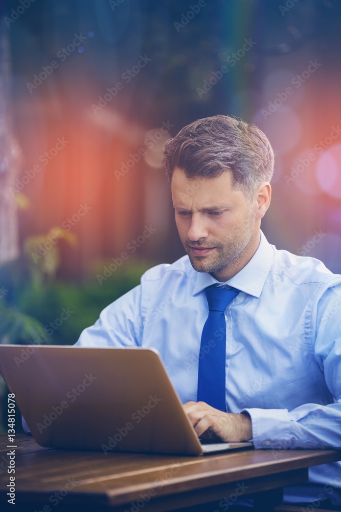 Confident businessman using laptop