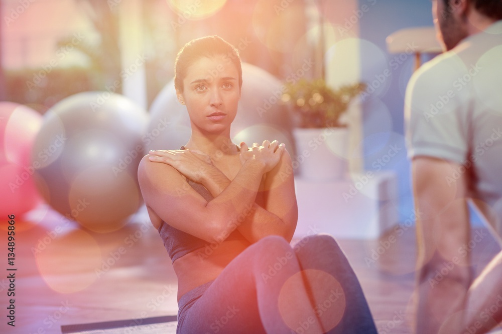 Physiotherapist assisting female patient while exercising