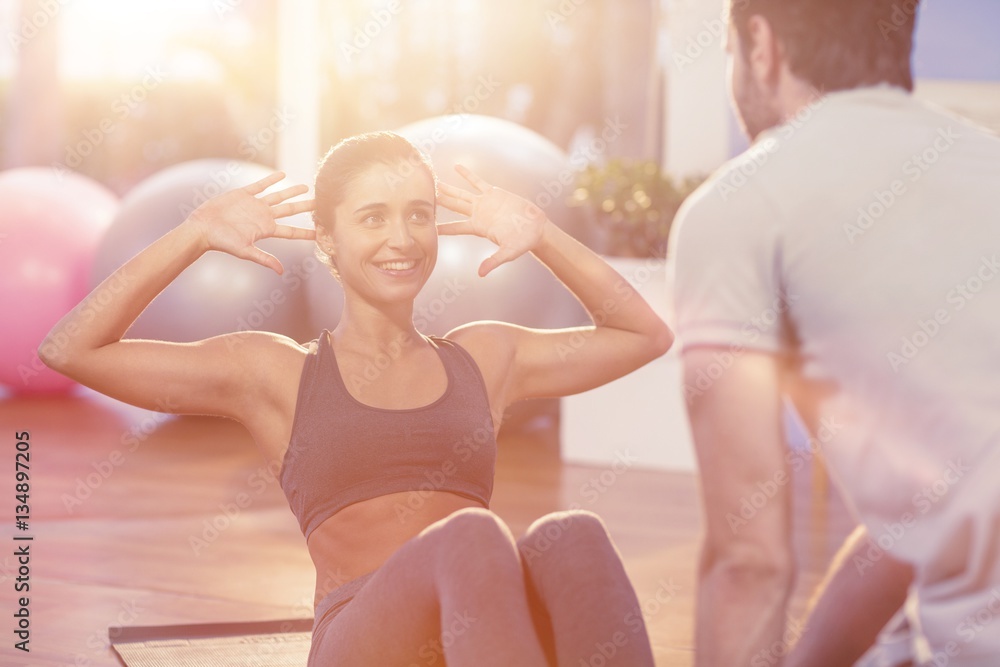 Physiotherapist assisting a female patient while exercising