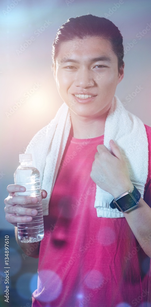 Portrait of man holding water bottle after workout