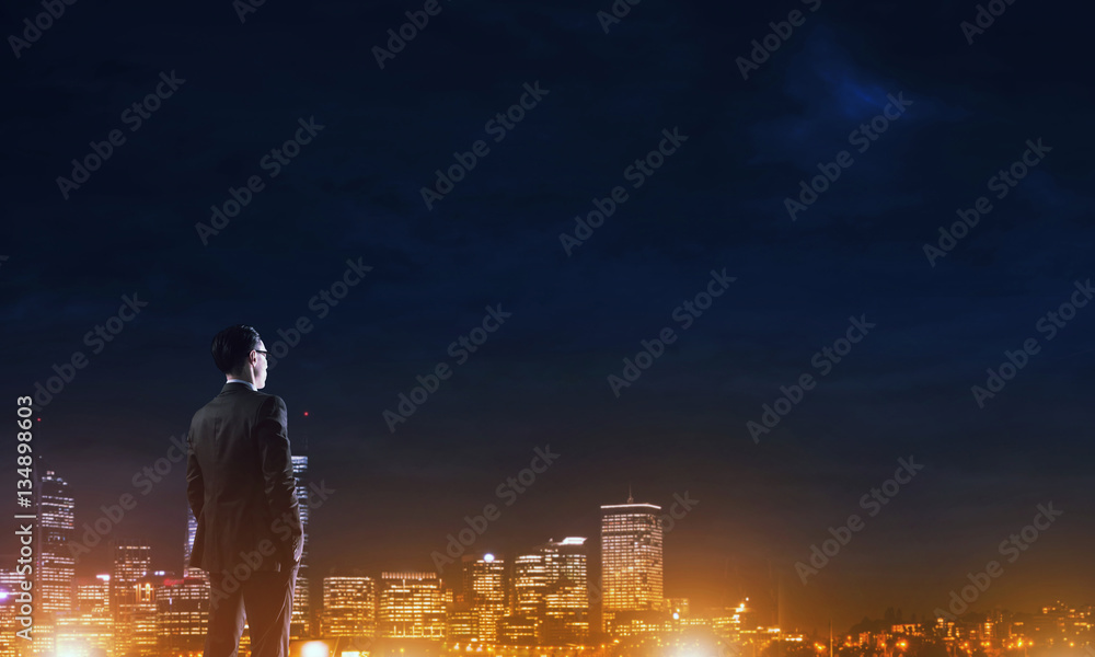 Businessman viewing night glowing city