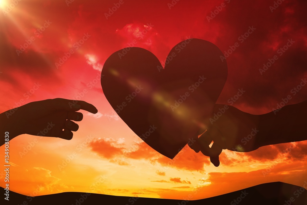 Composite image of couple passing a paper heart