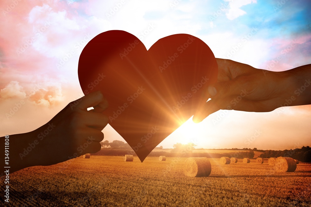 Composite image of hands holding red heart