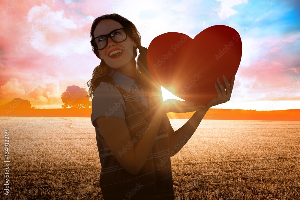 Composite image of geeky hipster woman holding heart card