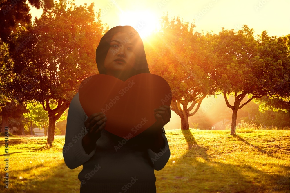 Composite image of asian woman holding paper heart