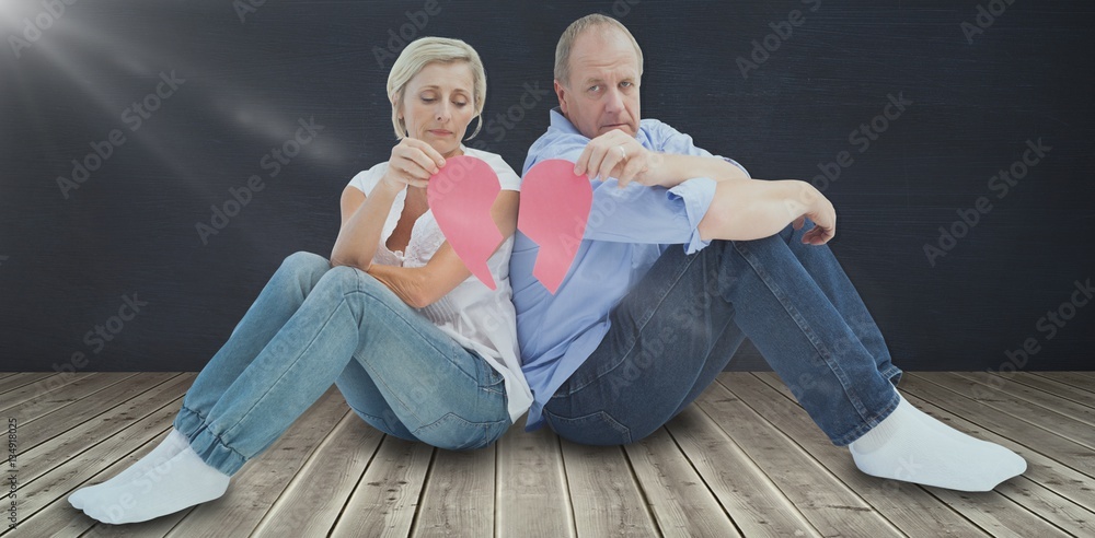 Composite image of sad mature couple holding a broken heart