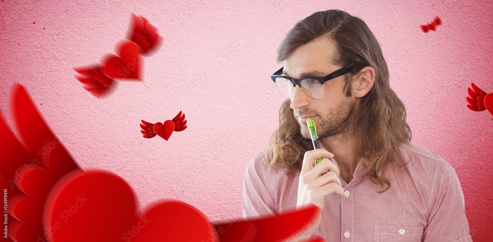 Composite image of thoughtful hipster holding pen and book