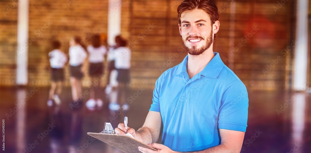 Portrait of sports teacher writing on clipboard