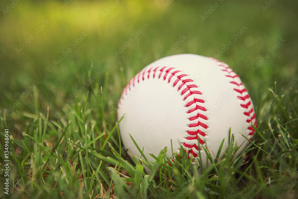 a baseball in the grass.