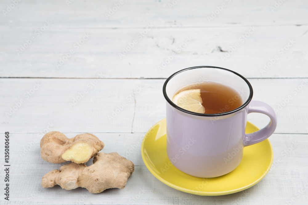 Ginger tea in a cup on wooden background