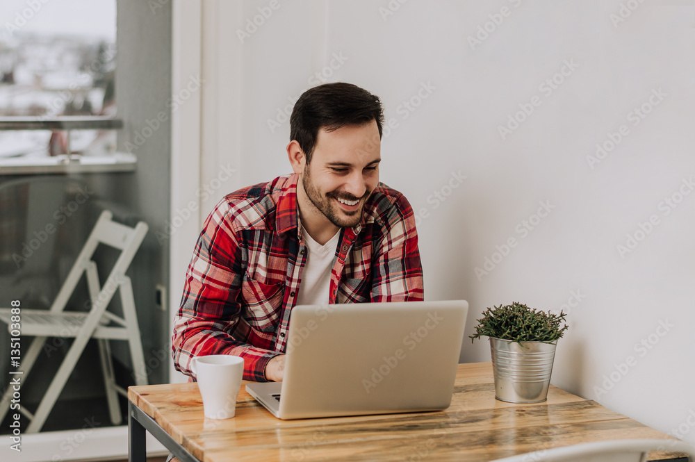 Confident expert at work. Handsome man using his laptop while si