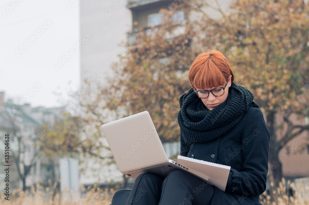 Beautiful young woman using laptop at outdoor