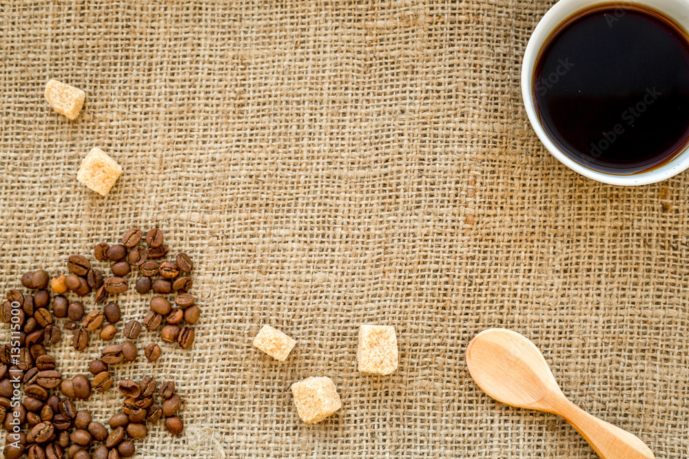 beans, ground coffee and sugar cane on linen cloth