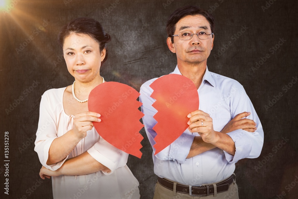 Composite image of couple holding broken heart