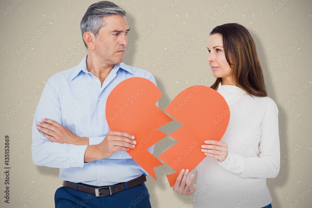 Composite image of couple holding broken heart shape paper