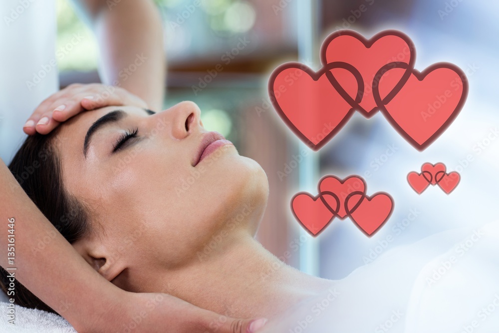 Composite image of woman receiving a massage with love hearts