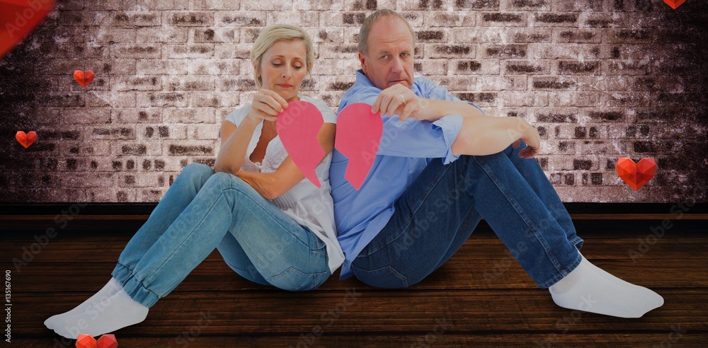 Composite image of sad mature couple holding a broken heart