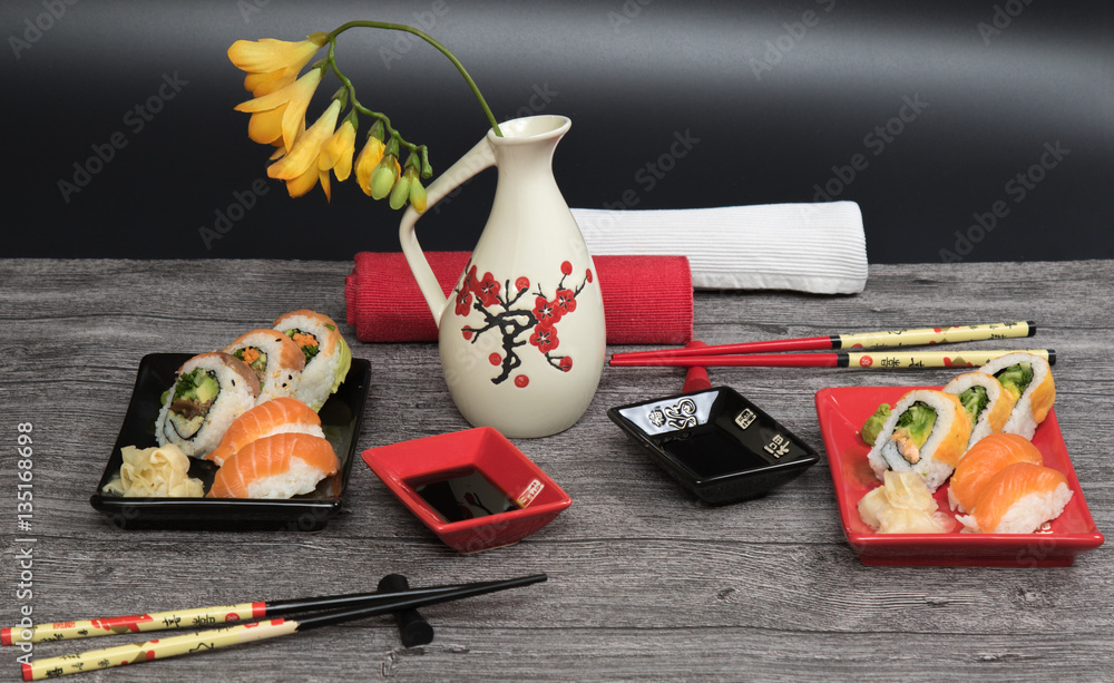 Sushi rolls set served for two on black and red tables on wooden table