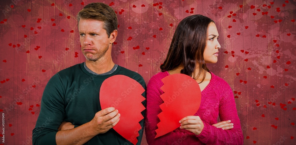 Composite image of serious couple holding cracked heart shape