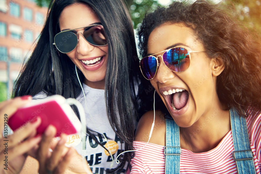 Female friends wearing sun glasses and smile