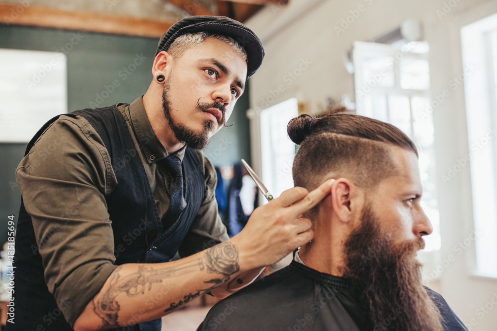 Barber checking symmetry of haircut