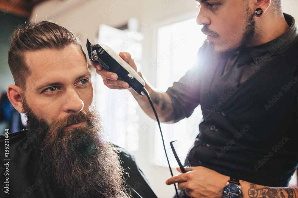 Young man getting haircut at barber shop