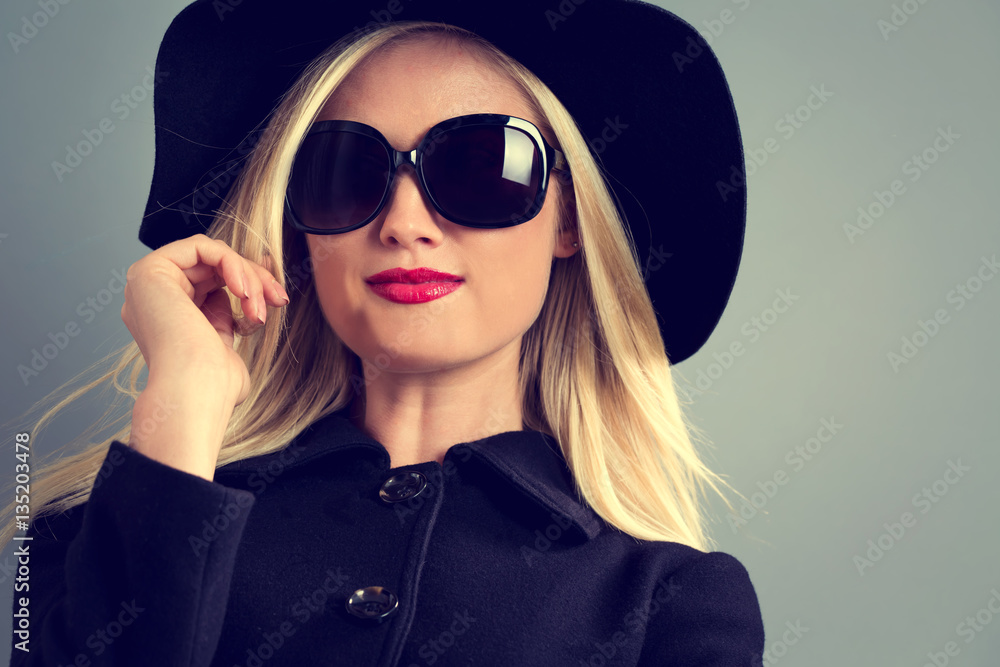 Beautiful young blonde woman in a black coat