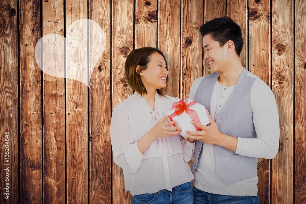 Composite image of young man giving present to woman