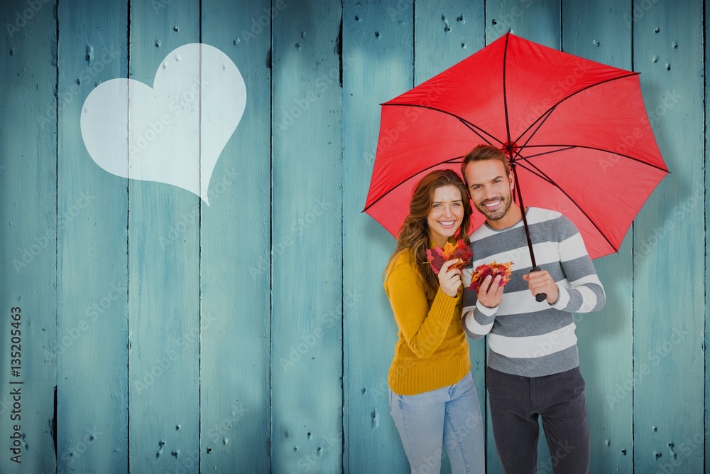 Composite image of happy young couple holding umbrella