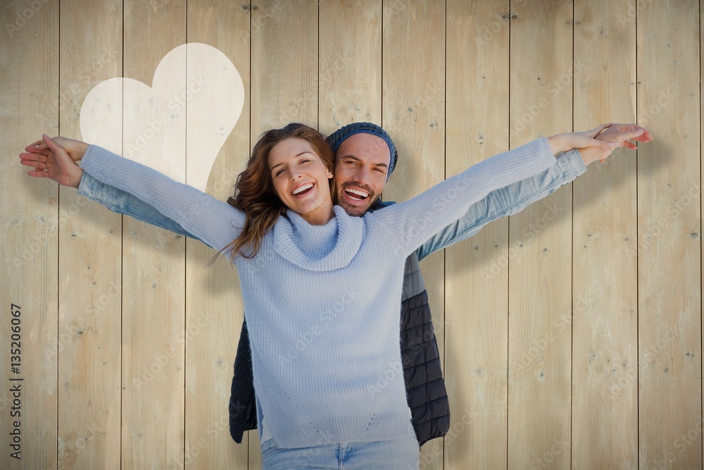 Composite image of happy couple standing with arms outstretched