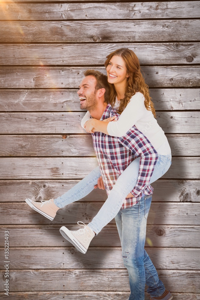 Composite image of man giving piggyback ride to woman