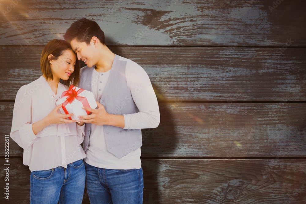 Composite image of young man giving present to woman