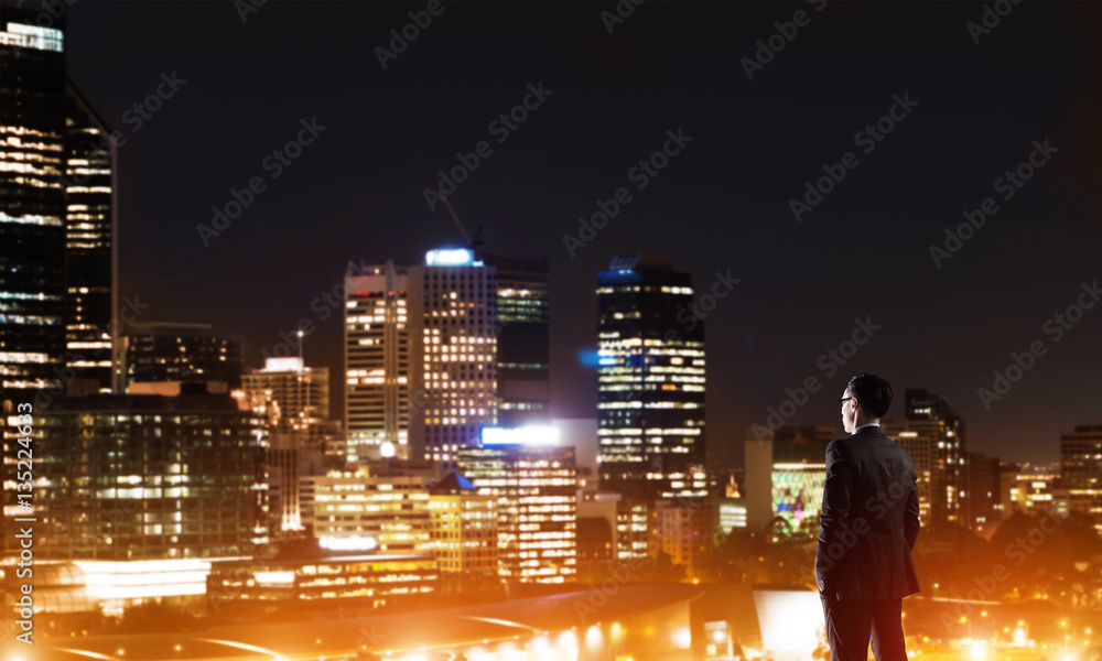 Businessman viewing night glowing city