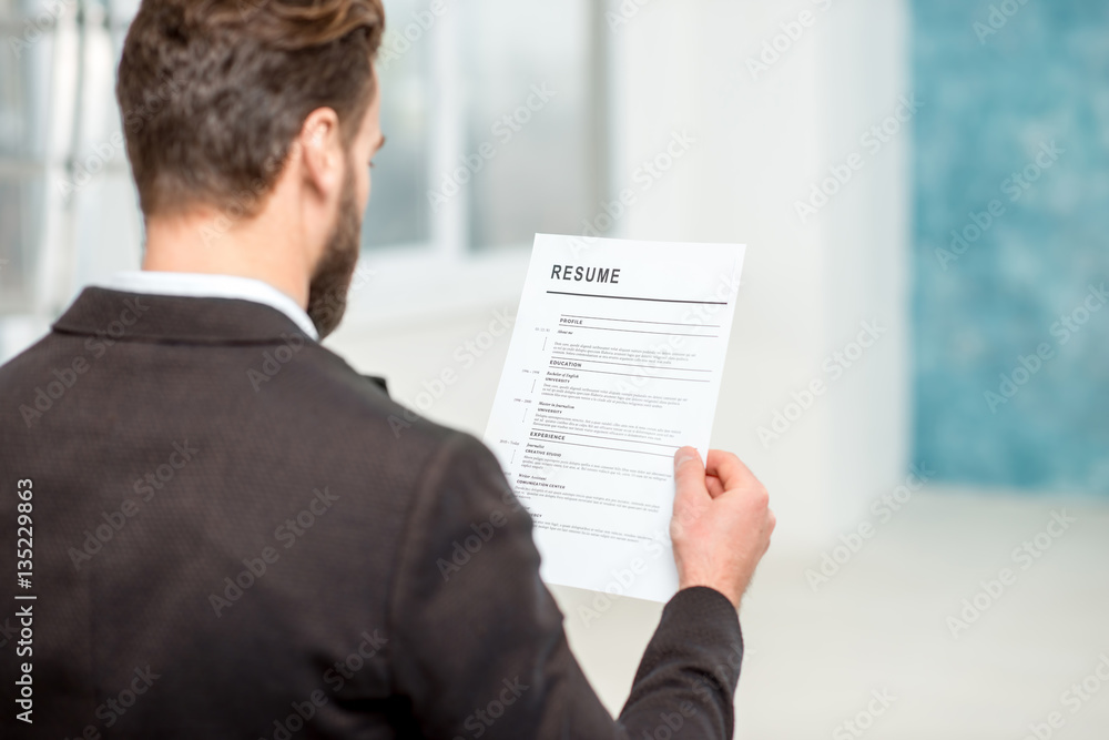 Elegant recruiter reading resume for job hiring in the office