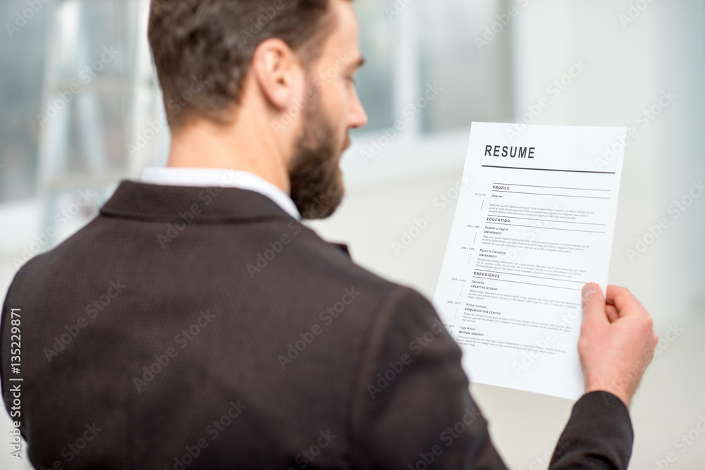 Elegant recruiter reading resume for job hiring in the office