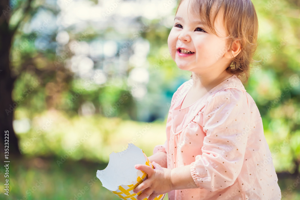 Portrait of a happy toddler girl playing with a big smile