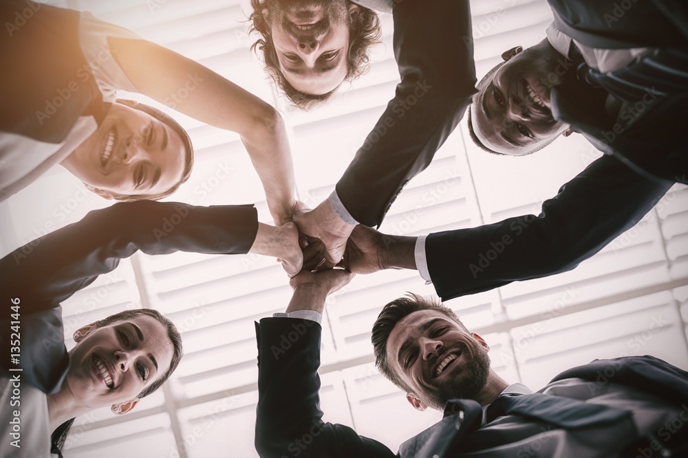 Group of happy businesspeople giving high five