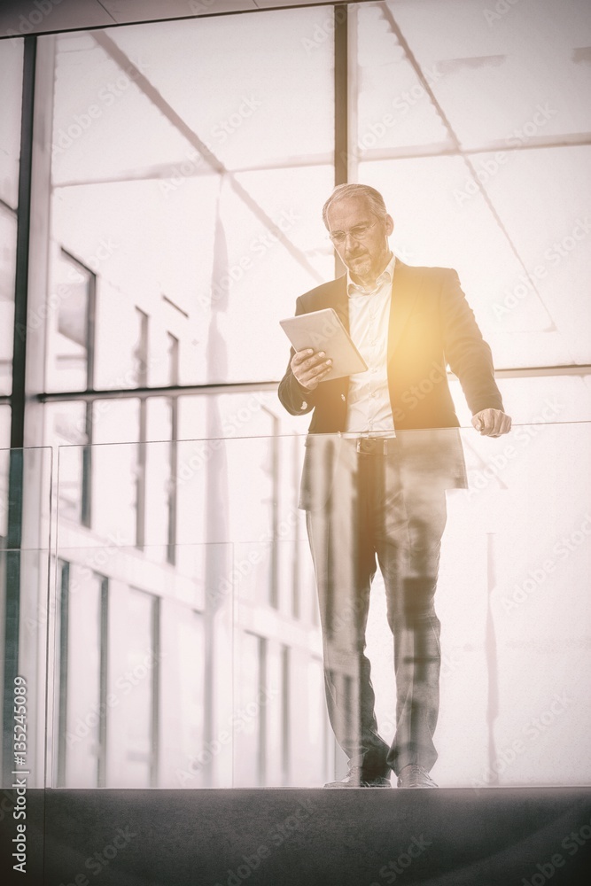 Serious businessman holding digital tablet