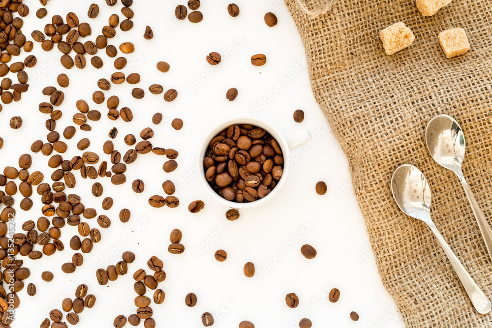 beans, ground coffee and sugar cane on linen cloth