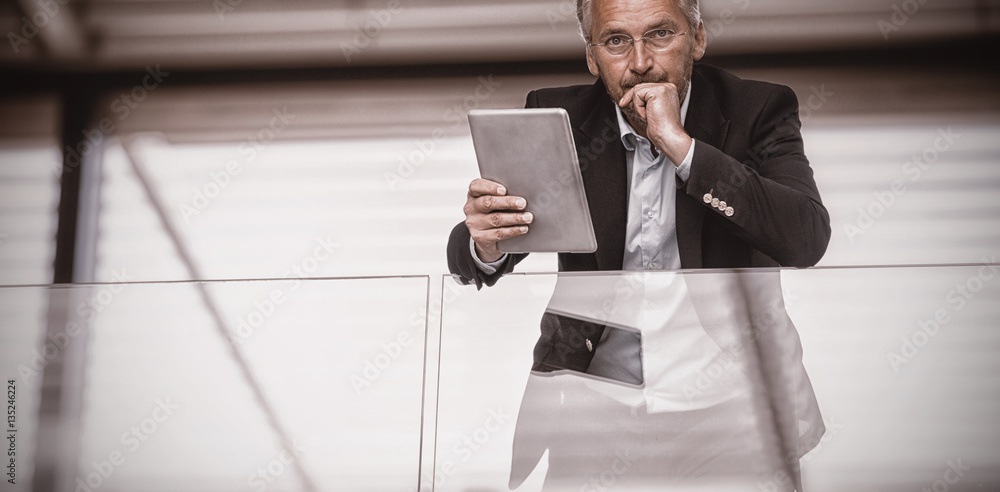 Serious businessman holding digital tablet