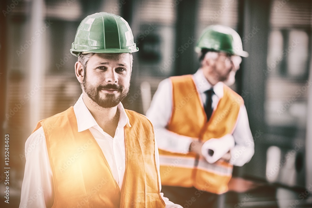 Architect in hard hat standing in office corridor