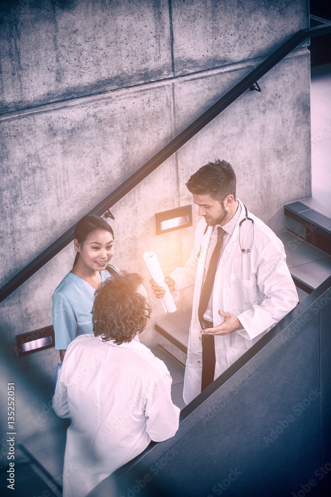 Doctors discussing with nurse on stairs