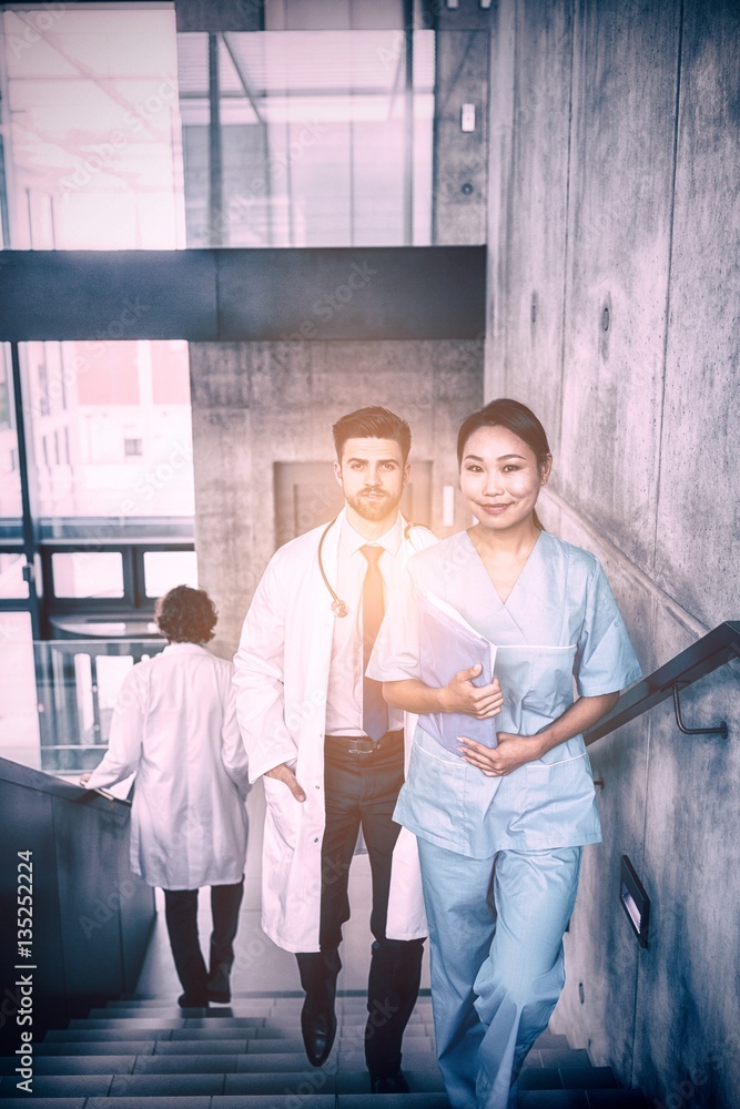 Doctor and nurse walking on staircase