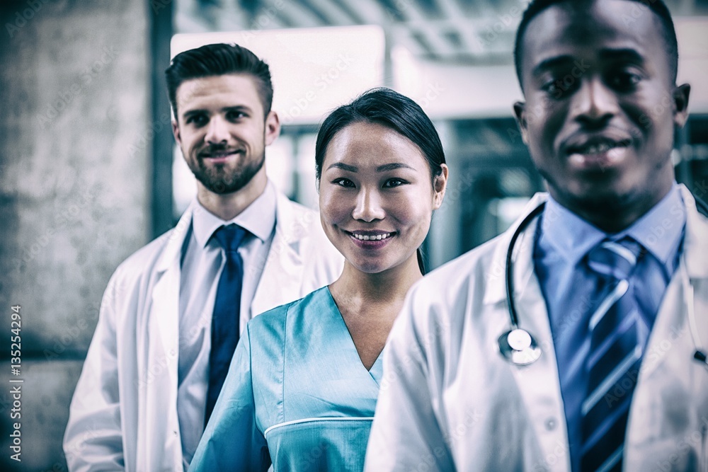 Confident nurse standing with colleagues