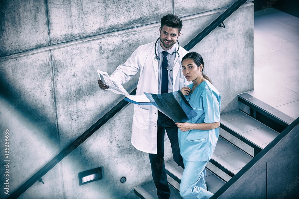 Portrait of doctor and nurse holding medical reports