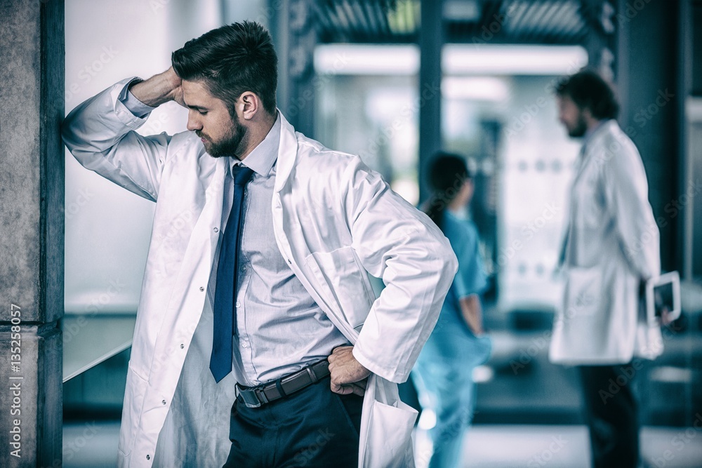 Stressed doctor standing in hospital