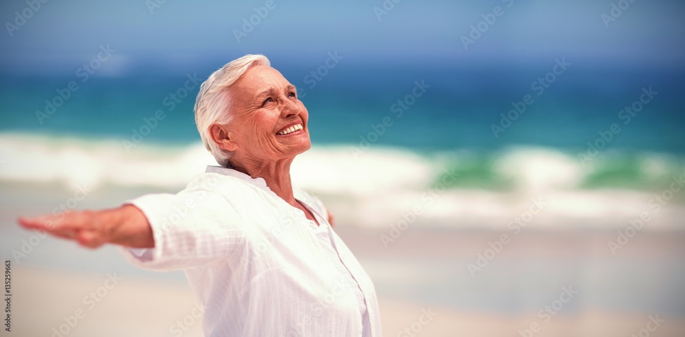 Side view of mature woman posing with arms outstretched