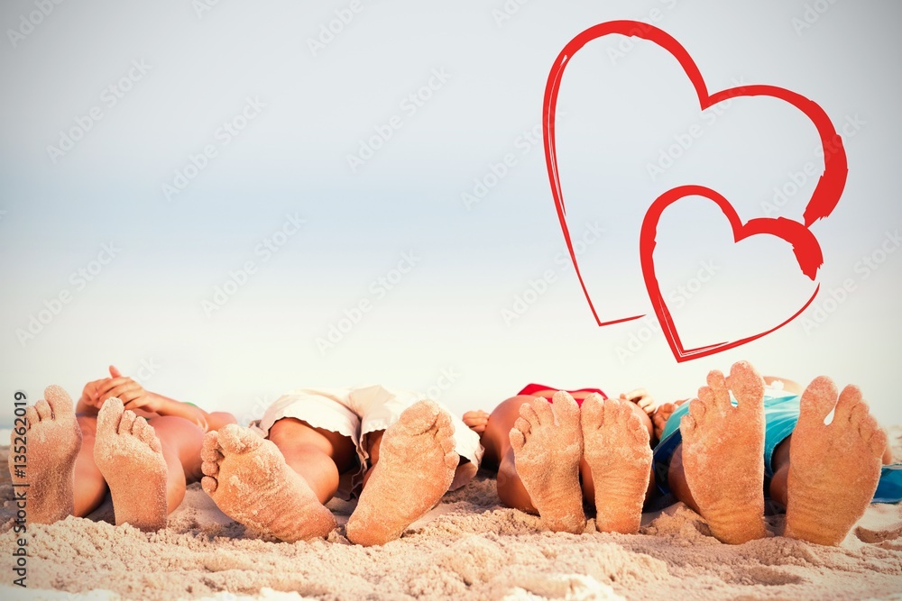 Composite image of feet of friends lying together