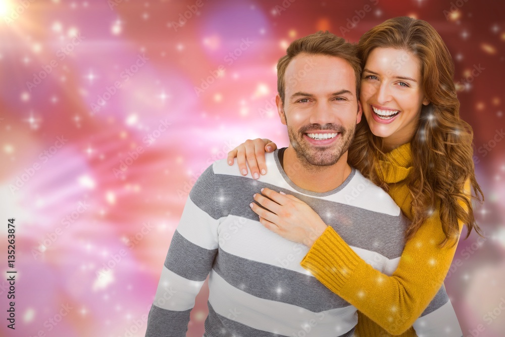 Composite image of portrait of cheerful young couple embracing